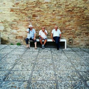 Person leaning on brick wall