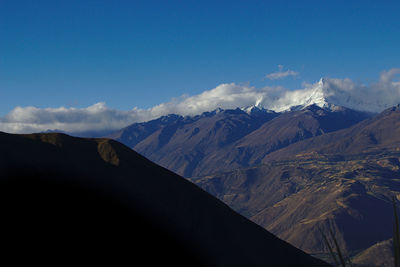 Scenic view of mountains against blue sky