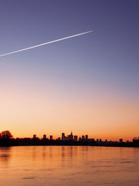Silhouette buildings against sky during sunset