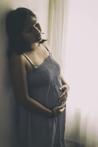 Pregnant woman standing by window