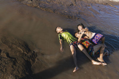 High angle view of friends enjoying at sea shore