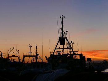 Silhouette trawler against sky during sunset