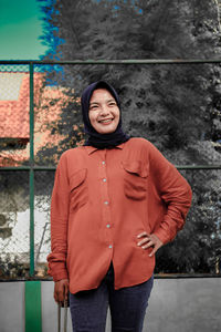 Portrait of smiling young woman standing outdoors