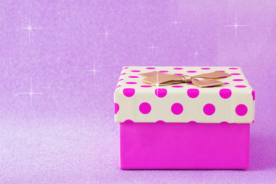 Close-up of pink paper box against colored background