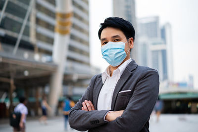 Portrait of young man standing in city