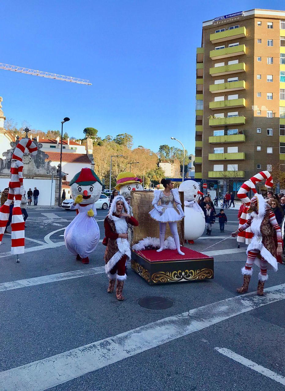 PEOPLE ON ROAD AGAINST BUILDINGS