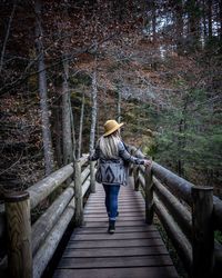 Rear view of woman on staircase in forest