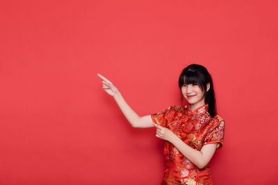 Portrait of young woman holding red umbrella