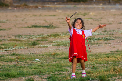 Portrait of cheerful girl playing on field