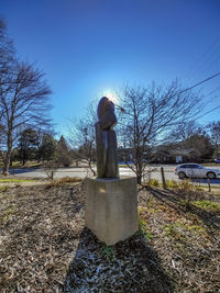 Statue on field against clear sky