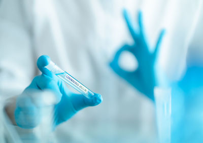 Close-up of human hand holding blue ring