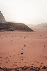 Rear view of man running on field