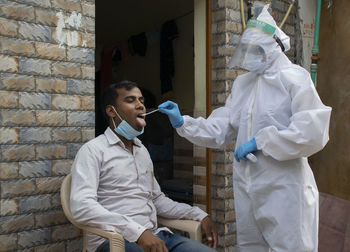 Doctor doing corona test at the door of house