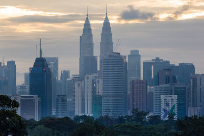 Skyscrapers in city against cloudy sky