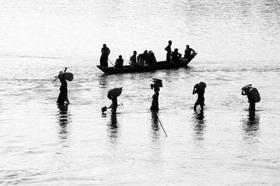 Silhouette people in sea