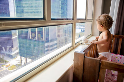 Boy looking through window