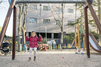 Children playing on swing at playground