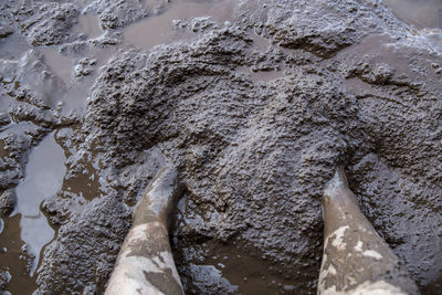 Low section of man standing in mud