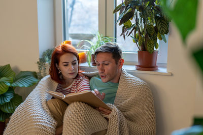 Portrait of young woman sitting on sofa at home