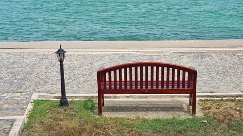 High angle view of empty bench on sea shore