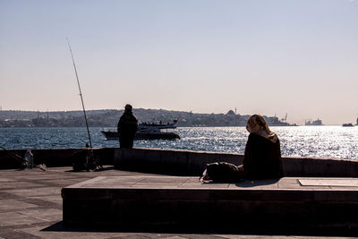 People at promenade against clear sky