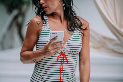 Midsection of woman using mobile phone