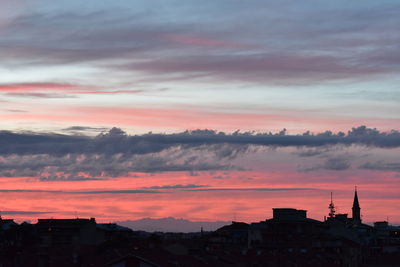 Silhouette buildings against sky at sunset