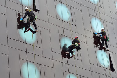 Low angle view of people working on building