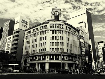 Low angle view of buildings against cloudy sky