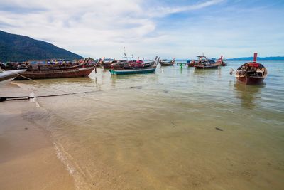 Boats moored on sea against sky