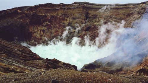 Panoramic view of smoke emitting from volcanic mountain