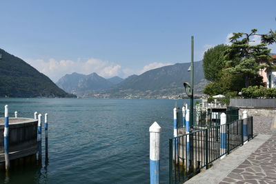 Scenic view of sea and mountains against clear blue sky