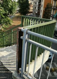 Fence by footpath against buildings in city