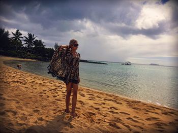 Rear view of woman standing on beach