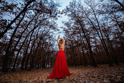 Woman standing on field in forest