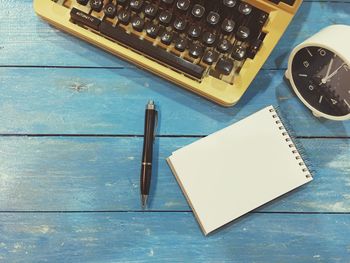 High angle view of note pad and typewriter