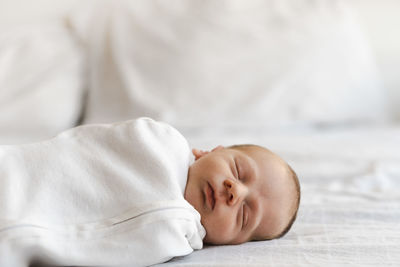Newborn baby boy of bed at home