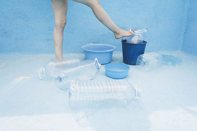 Woman standing by plastic bottle in empty pool