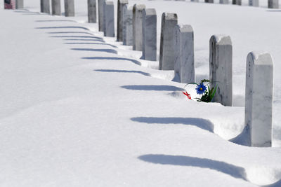 Graveyard markers in a row under snow covering
