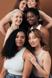 Portrait of smiling women against brown background