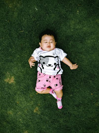 High angle portrait of cute baby girl on field