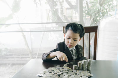 Boy looking through window on table