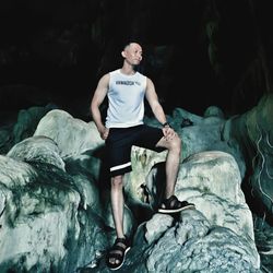 Young man sitting on rock