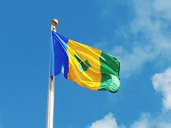 Low angle view of flag against blue sky