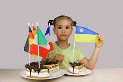 Portrait of woman holding gift box against white background