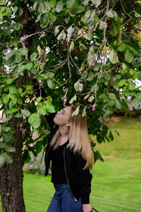 Woman standing by tree