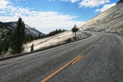 Road by mountain against sky