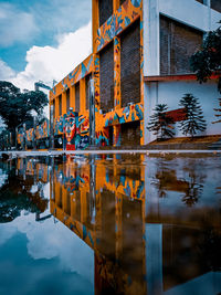 Reflection of building in lake against sky