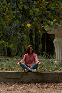 Portrait of young woman sitting on footpath