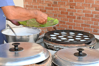 Midsection of man preparing food in kitchen